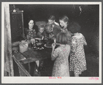 Woman migrant packinghouse worker from Tennessee with four children and two relatives eating supper. Belle Glade, Florida