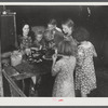 Woman migrant packinghouse worker from Tennessee with four children and two relatives eating supper. Belle Glade, Florida