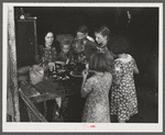 Woman migrant packinghouse worker from Tennessee with four children and two relatives eating supper. Belle Glade, Florida