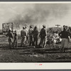 Negro agricultural laborers watching one of their houses burn to the ground. All they have left is piled on the ground. Lake Harbor, Florida