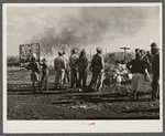 Negro agricultural laborers watching one of their houses burn to the ground. All they have left is piled on the ground. Lake Harbor, Florida