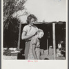 Young woman packinghouse worker from Tennessee, trying to get the black muck, which causes an itchy rash and sores and scabs on scalp, out of her oldest child's hair. The water is from the dirty canal nearby. She has three other children. Belle Glade, FL.