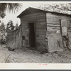 Migrant vegetable pickers and packinghouse workers living quarters. This shack rents for eight dollars a month: no water, light, or sanitary facilities. Eleven people sleep in it. Near Canal Point, Florida