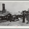 Tenant farmer and wife looking at ruins of home burned to ground. Greene County, Georgia
