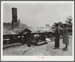 Tenant farmer and wife looking at ruins of home burned to ground. Greene County, Georgia
