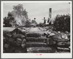 Farm wagehand (day laborer, seventy-five cents per day) and his young wife looking at remains of their home (on three acre piece of land owned by his mother) which had just burned to the ground. Greene County, Georgia