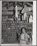 Mrs. Brown in her smokehouse with home-canned goods and cured meat. Prairie Farms, Alabama