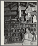 Mrs. Brown in her smokehouse with home-canned goods and cured meat. Prairie Farms, Alabama