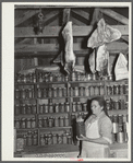 Mrs. Brown in her smokehouse with home-canned goods and cured meat. Prairie Farms, Alabama