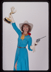 Susan Lucci holding an Emmy Award in a publicity photograph for Annie Get Your Gun