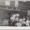 English lesson in sixth and seventh grade school room. Selma Sutton at board with teacher, Miss Jessie West Greene. Flint River Farms, Georgia