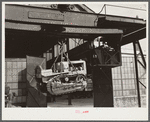 Shepard crane lifting tractor brought to FSA (Farm Security Administration) warehouse depot for repairs. Atlanta, Georgia