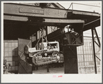 Shepard crane lifting tractor brought to FSA (Farm Security Administration) warehouse depot for repairs. Atlanta, Georgia