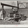 Repaired tractor being loaded from bank to truck ready to leave FSA (Farm Security Administration) warehouse depot in Atlanta, Georgia