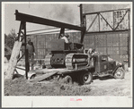 Repaired tractor being loaded from bank to truck ready to leave FSA (Farm Security Administration) warehouse depot in Atlanta, Georgia