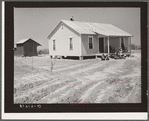 New home and smokehouse of Charles McGuire (tenant purchase borrower) with his wife and children on front porch. Pike County, Alabama