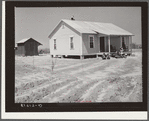 New home and smokehouse of Charles McGuire (tenant purchase borrower) with his wife and children on front porch. Pike County, Alabama