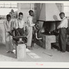 O.C. Cramer, Frederick West, J.W. West and another student sharpening plow point at forge in school shop. Flint River Farms, Georgia