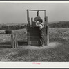 Lewis boy getting water from old well, typical of most in area where wells are very often polluted. Coffee County, Alabama