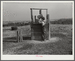 Lewis boy getting water from old well, typical of most in area where wells are very often polluted. Coffee County, Alabama