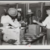 Black day laborers brought in truck from nearby towns, waiting to be paid off for cotton picking and buy supplies inside plantation store on Friday night. Marcella Plantation. Mississippi Delta. Mississippi