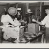 Black day laborers brought in truck from nearby towns, waiting to be paid off for cotton picking and buy supplies inside plantation store on Friday night. Marcella Plantation. Mississippi Delta. Mississippi