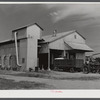 Modern gin and dryer with cotton brought in from fields by a tractor pulling large truck instead of smaller wagons. Truck holds eight bales of cotton. Hopson Plantation, near Clarksdale. Mississippi Delta, Mississippi