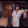 Restaurant worker in front of kitchen murals, Symposium Restaurant