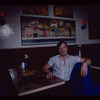 Restaurant worker seated at booth, Symposium Restaurant