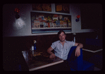 Restaurant worker seated at booth, Symposium Restaurant