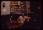 Restaurant worker seated at booth, Symposium Restaurant