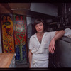 Restaurant worker in front of kitchen murals, Symposium Restaurant