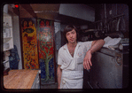 Restaurant worker in front of kitchen murals, Symposium Restaurant