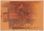 Restaurant worker in blue shirt in front of painting, Nea Hellas