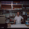 Grocer with white shirt behind counter, Grocer #2