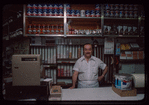 Grocer with white shirt behind counter, Grocer #2