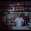 Grocer with white shirt behind counter, Grocer #2