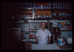 Grocer with white shirt behind counter, Grocer #2