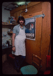 Grocer with grey shirt by poster, Grocer #2