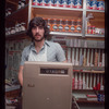 Grocer with grey shirt behind counter, Grocer #2