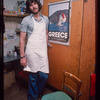 Grocer with grey shirt by poster, Grocer #2