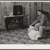 Project farmer with his cotton samples in the living room of his new home. Sunflower Plantations, Merigold, Mississippi Delta
