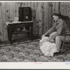 Project farmer with his cotton samples in the living room of his new home. Sunflower Plantations, Merigold, Mississippi Delta