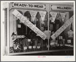 Signs on store window advertising sales during tobacco auction time in Zebulon. Wake County, North Carolina