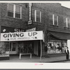 Signs on store fronts advertising sales during tobacco auction season in Zebulon, North Carolina