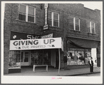 Signs on store fronts advertising sales during tobacco auction season in Zebulon, North Carolina