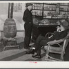 Mr. R.B. Whitley (in chair) visiting in his general store. He is president of the bank and practically owns and runs the town. He is a big landowner, owns Whitley-Davis farm and a cotton mill in Clayton. He said he cut down the trees and pulled up the