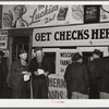 Farmers getting their checks in warehouse office after their tobacco has been sold at auction. Durham, North Carolina