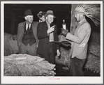 Farmers listening to sales talk of patent medicine vendor in warehouse during tobacco auctions. Durham, North Carolina