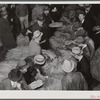 Auctioneer, buyers, and farmers during tobacco auction sale. Warehouse, Durham, North Carolina